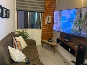a living room with a couch and a large screen tv at Reservas del peñon in Girardot