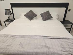 a large white bed with two pillows on it at Samaris Résidences in Nouakchott