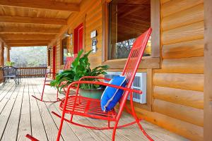 two red chairs sitting on the porch of a cabin at Wimberley Log Cabins Resort and Suites- Unit 7 in Wimberley