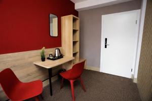 a room with a table and two red chairs at NIVAN Hostel in Hamburg +10 photos