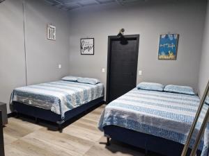 a bedroom with two beds and a door at Casabela in Comayagua
