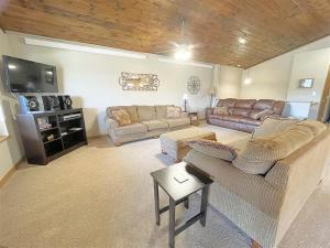 a living room with two couches and a tv at Prospector in Hill City