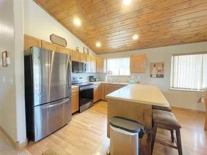 a kitchen with a stainless steel refrigerator and wooden cabinets at Prospector in Hill City