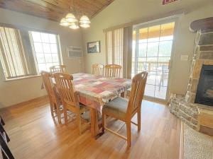 a dining room with a table and chairs and a fireplace at Prospector in Hill City