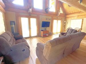 a living room with couches and a flat screen tv at Granite Ridge Cabin in Keystone