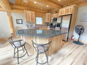 a kitchen with a counter and two bar stools at Granite Ridge Cabin in Keystone