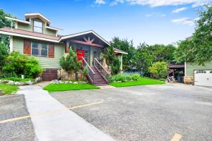 a house with a red door and a driveway at Clutter Falls Retreat - Main House in New Braunfels