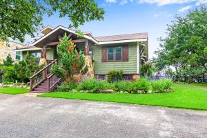 a green house with a garden in front of it at Clutter Falls Retreat - Main House in New Braunfels +30 photos