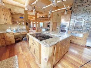 a large kitchen with wooden cabinets and a stone wall at Granite Ridge Lodge in Keystone