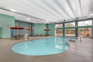 a large pool in a room with tables and umbrellas at Best Western Holiday Lodge in Clear Lake