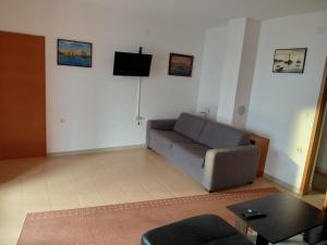 a living room with a couch and a tv on the wall at Kuća za odmor STIPE in Pag