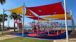 a park with a playground with umbrellas at Sea180 in Nahariyya