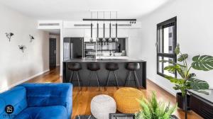 a living room with a blue couch and a kitchen at Sea180 in Nahariyya