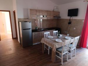 a kitchen with a table with chairs and a refrigerator at Kuća za odmor STIPE in Pag