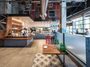 a restaurant with a table and people in the kitchen at Art Series - The Larwill Studio in Melbourne