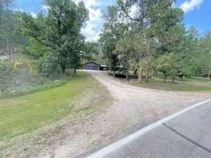 a dirt road leading to a house with trees at Keystone Crossing in Keystone