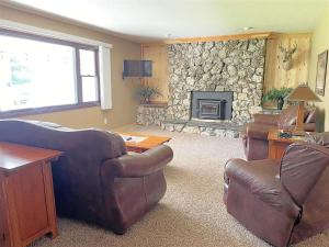 a living room with leather furniture and a stone fireplace at Keystone Crossing in Keystone