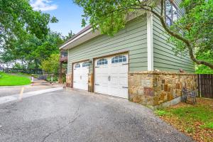 a garage with two white garage doors on a house at Clutter Falls Retreat - Guest House in New Braunfels