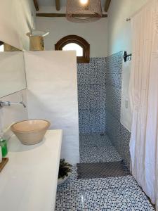 a bathroom with a shower with a bowl on the counter at Chalé Rosa in Trancoso +13 photos
