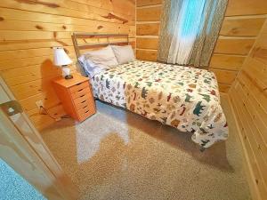 a small bedroom with a bed and a night stand at Schuster's Cabin in Custer +15 photos