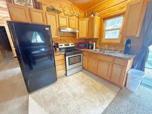 a kitchen with a black refrigerator and a sink at Schuster's Cabin in Custer