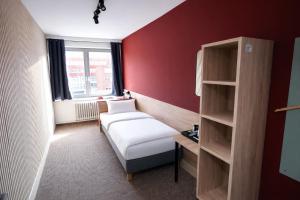 a small room with a bed and a book shelf at NIVAN Hostel in Hamburg