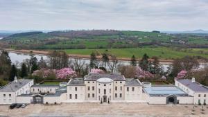 an aerial view of a large white house with a river at The Greenway Getaway in Abbeyside