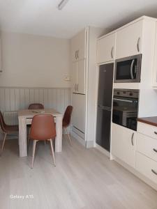 a kitchen with a table and chairs and a microwave at The Greenway Getaway in Abbeyside +30 photos