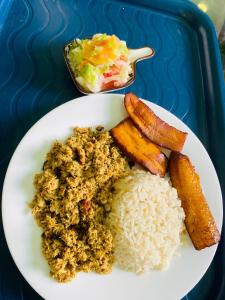 a white plate of food with rice and vegetables at Hotel Y Transporte LadyMar in Nuquí