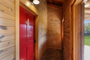 a red door in a wooden walled room at Wimberley Log Cabins Resort and Suites- Unit 4 in Wimberley