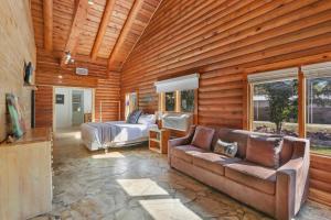 a living room with a couch and a bed and a bedroom at Wimberley Log Cabins Resort and Suites- Unit 4 in Wimberley +12 photos