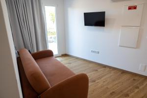 a living room with a couch and a television at Trio Living Residences in Vila Real