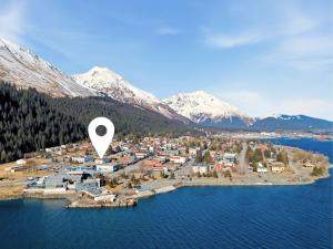 an island in the water with a town and mountains at Hotel North in Seward
