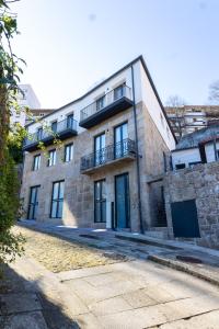 a large brick building with balconies on a street at Trio Living Residences in Vila Real