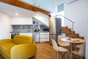 a living room with a yellow couch and a table at Trio Living Residences in Vila Real