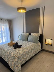 a bedroom with a bed with a stuffed animal on it at Appartement cosy entièrement équipé in Villeneuve-sur-Lot