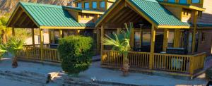 a house with a green roof and a porch at Pirate Cove Resort in Needles