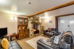 a living room with a leather couch and a stone fireplace at 2 Bed in Eggleston oc-l30452 in Middleton in Teesdale