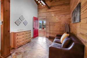 a living room with a couch and a red door at Wimberley Log Cabins Resort and Suites- Unit 3 in Wimberley