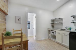 a kitchen with white walls and a wooden table at Wimberley Log Cabins Resort and Suites- Unit 3 in Wimberley +11 photos