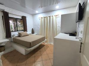 a bedroom with a bed and a television in it at Candelaria 5 Moterrico in Taxisco