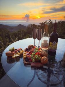 a table with a plate of food and a bottle of wine at Domos Mirador Romantic Private Honeymoon Glamping in Miramar