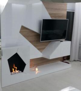 a living room with a fireplace and a tv at Blue Seaside Apartment in Gdańsk