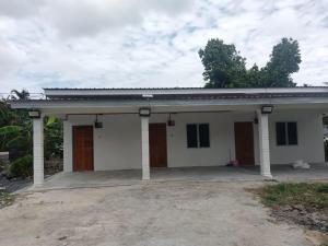 a small white house with a driveway at Tiny House Anjung Batu Tangkak in Tangkak