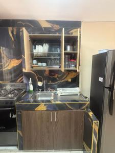 a kitchen with a sink and a refrigerator at Aptos KARS in Ríohacha