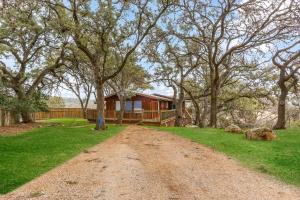a dirt road in front of a house with trees at Ricks River Haus in Canyon Lake