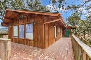 a wooden cabin with a wooden deck at Ricks River Haus in Canyon Lake