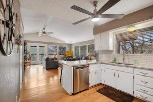 a kitchen with white cabinets and a ceiling fan at Ricks River Haus in Canyon Lake
