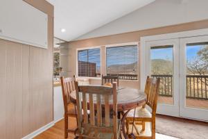 a dining room with a table and chairs and windows at Ricks River Haus in Canyon Lake +34 photos