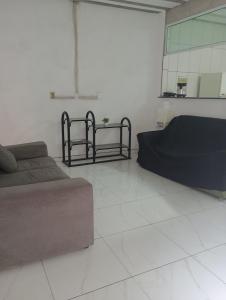 a living room with two beds and a couch at Renascer in São Pedro da Aldeia